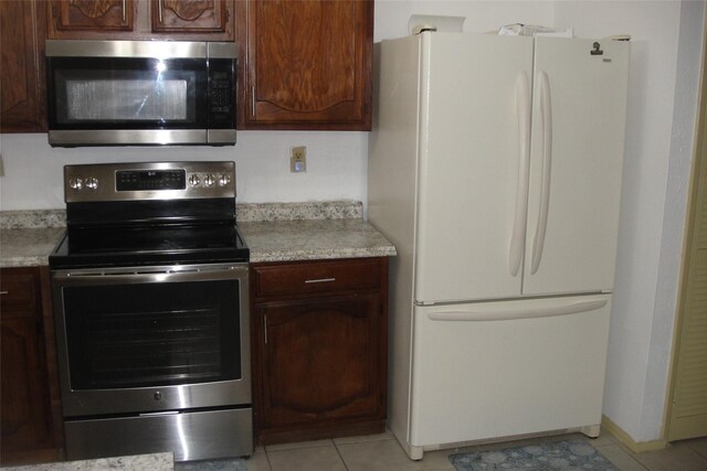 kitchen featuring stainless steel appliances, light countertops, and dark brown cabinetry