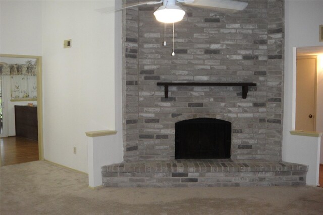 interior details featuring carpet floors, a fireplace, and a ceiling fan