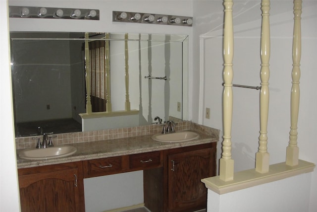 bathroom featuring a sink, decorative backsplash, and double vanity