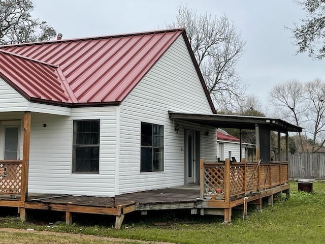 rear view of house with a lawn and a wooden deck