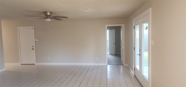 tiled empty room featuring ceiling fan