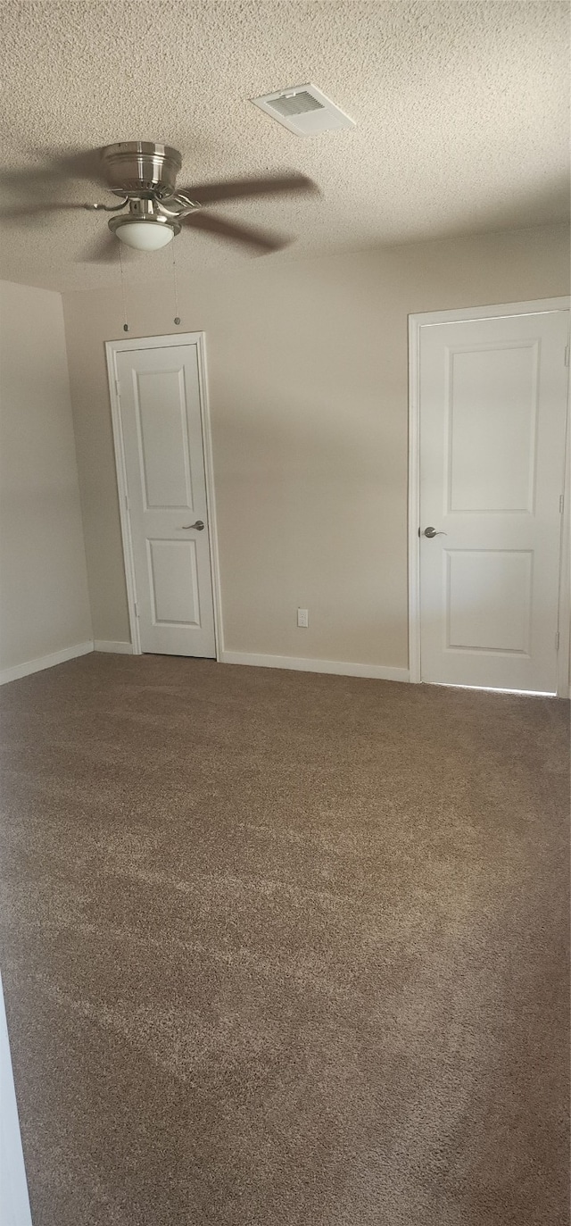 carpeted spare room with ceiling fan and a textured ceiling