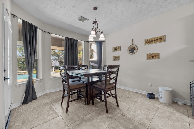 dining space featuring visible vents, a textured ceiling, and baseboards