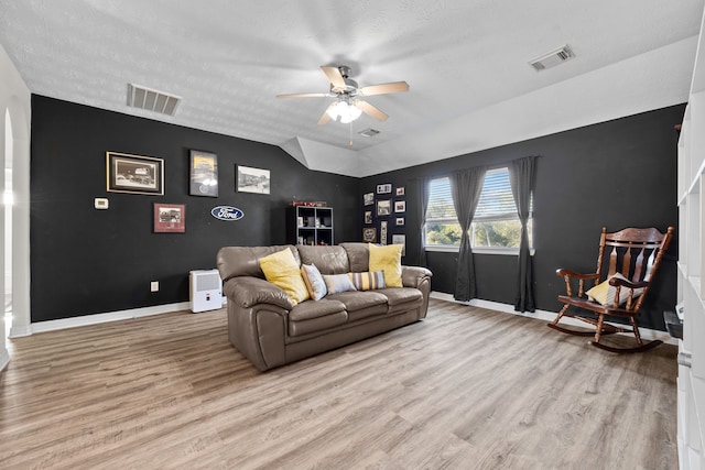 living room featuring light wood finished floors, baseboards, visible vents, and ceiling fan