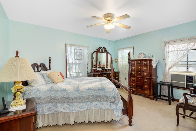 bedroom featuring multiple windows, light colored carpet, and ceiling fan