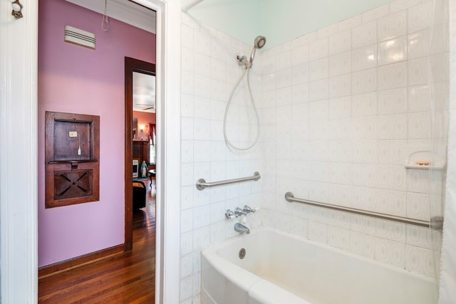 bathroom featuring wood-type flooring and tiled shower / bath