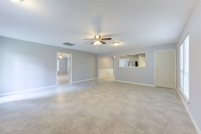 spare room featuring ceiling fan and plenty of natural light