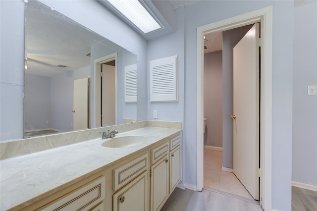 bathroom with hardwood / wood-style floors, vanity, and toilet