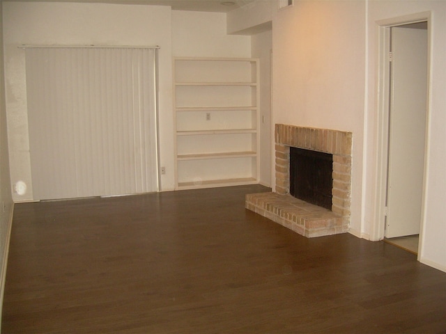 unfurnished living room featuring a fireplace and dark wood-type flooring