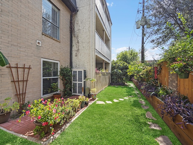 view of yard featuring a balcony and central AC unit