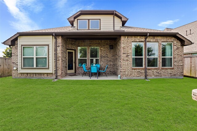 rear view of property with a lawn and a patio area