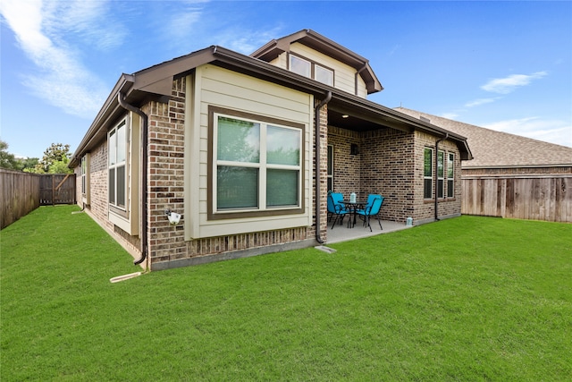 rear view of property with a lawn and a patio