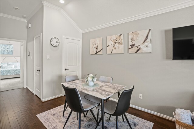 dining room with ornamental molding, lofted ceiling, and dark hardwood / wood-style floors