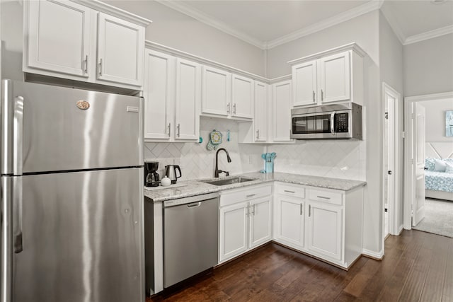 kitchen with dark hardwood / wood-style floors, sink, white cabinets, stainless steel appliances, and crown molding