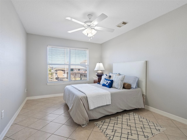bedroom with light tile patterned flooring, visible vents, ceiling fan, and baseboards
