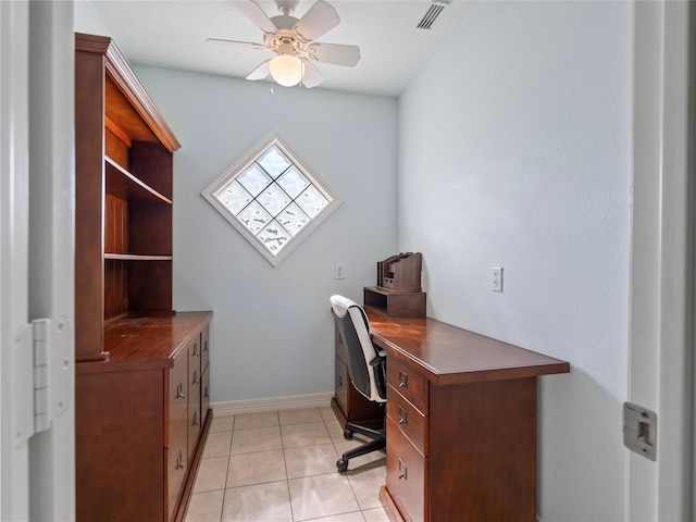 office space with baseboards, visible vents, a ceiling fan, and light tile patterned flooring