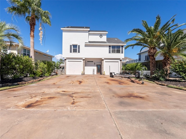 view of front of property featuring a garage, driveway, and roof with shingles