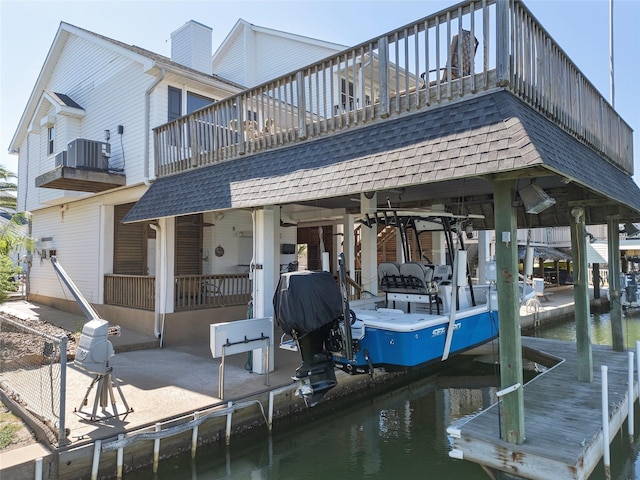 view of dock with a water view, boat lift, and central AC unit