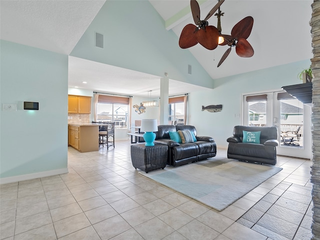 tiled living room with a textured ceiling, high vaulted ceiling, and ceiling fan with notable chandelier