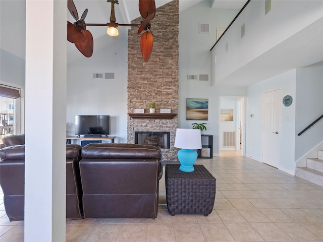 tiled living room featuring high vaulted ceiling, a fireplace, and ceiling fan