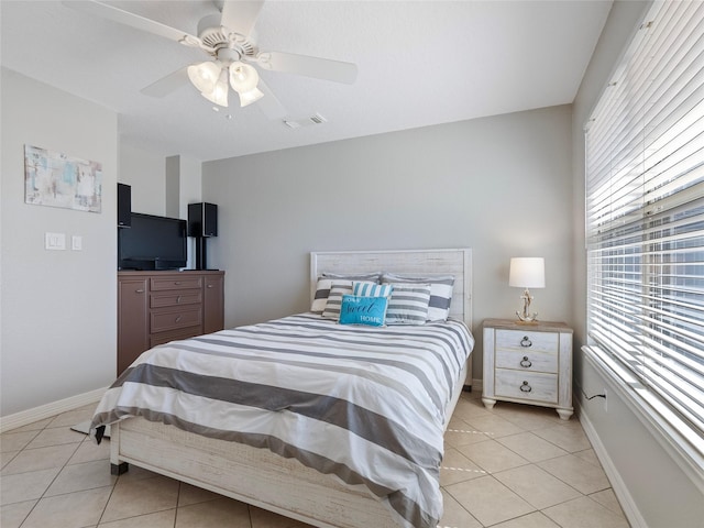 bedroom featuring light tile patterned floors, visible vents, a ceiling fan, and baseboards