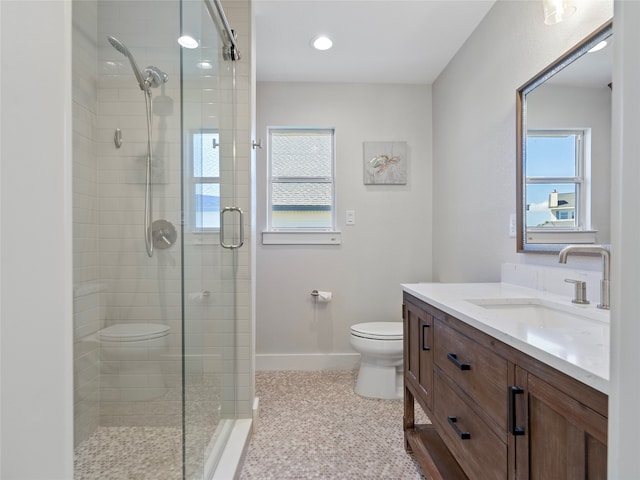 bathroom with vanity, toilet, plenty of natural light, and an enclosed shower