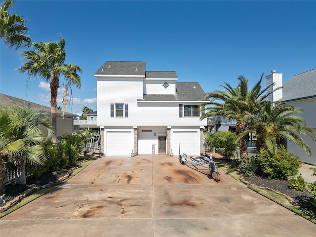 view of front facade featuring driveway, a garage, and roof with shingles