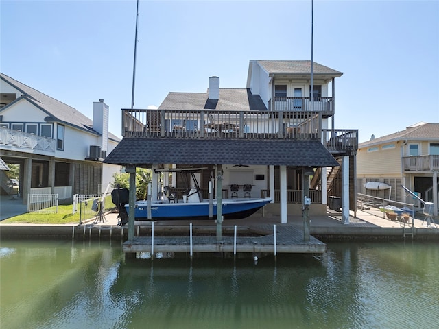 back of property with a deck with water view and a balcony