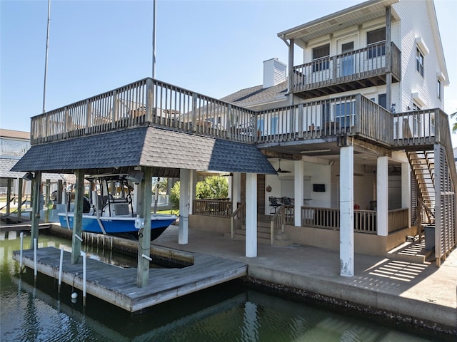 dock area featuring stairs, a water view, and boat lift