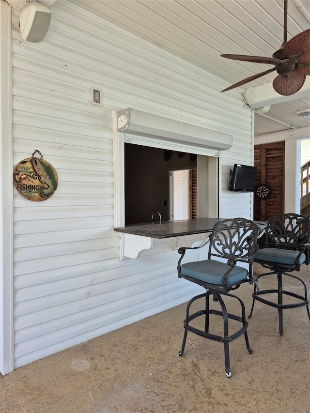 view of patio / terrace with a ceiling fan and exterior bar