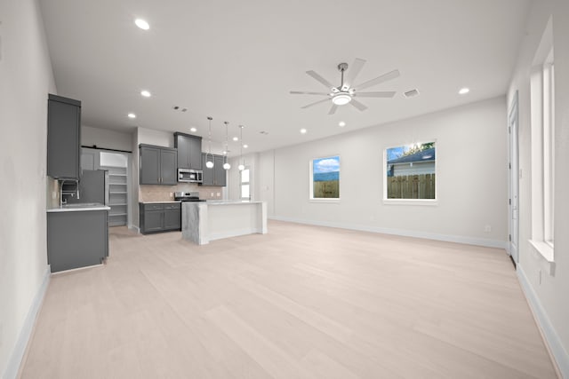 unfurnished living room featuring light hardwood / wood-style floors and ceiling fan