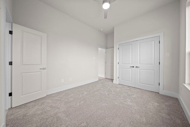 unfurnished bedroom featuring a closet, ceiling fan, and light colored carpet