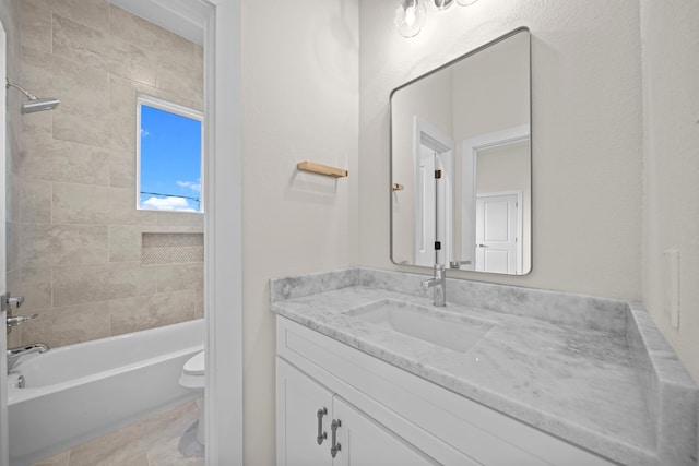 full bathroom with toilet, tiled shower / bath combo, and vanity