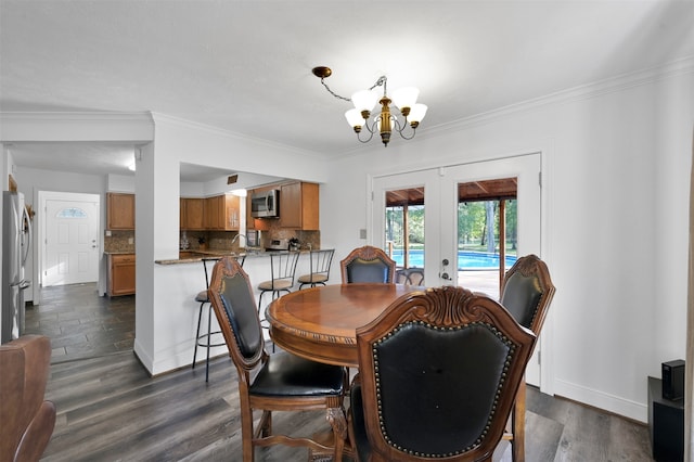 dining room with ornamental molding, dark hardwood / wood-style flooring, a chandelier, and french doors