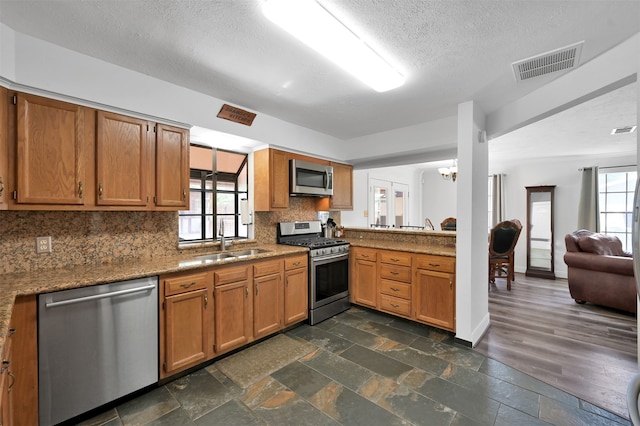 kitchen featuring appliances with stainless steel finishes, dark hardwood / wood-style floors, a healthy amount of sunlight, and sink