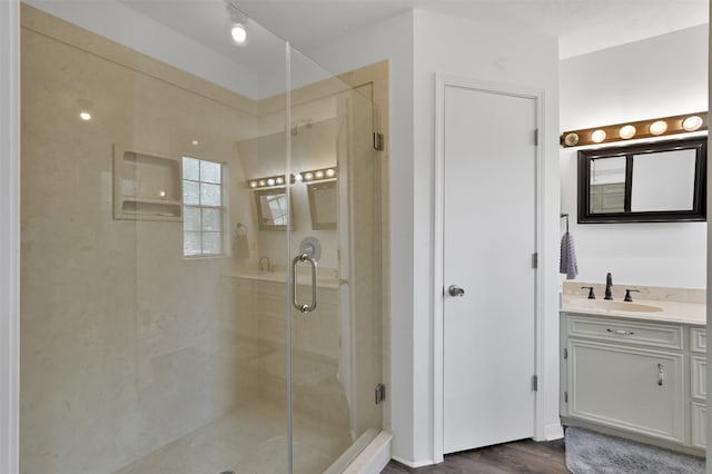 bathroom featuring wood-type flooring, walk in shower, and vanity