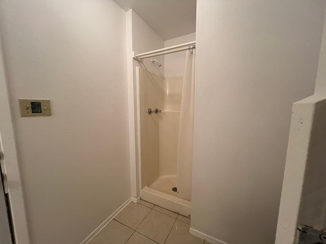 bathroom with walk in shower and tile patterned flooring