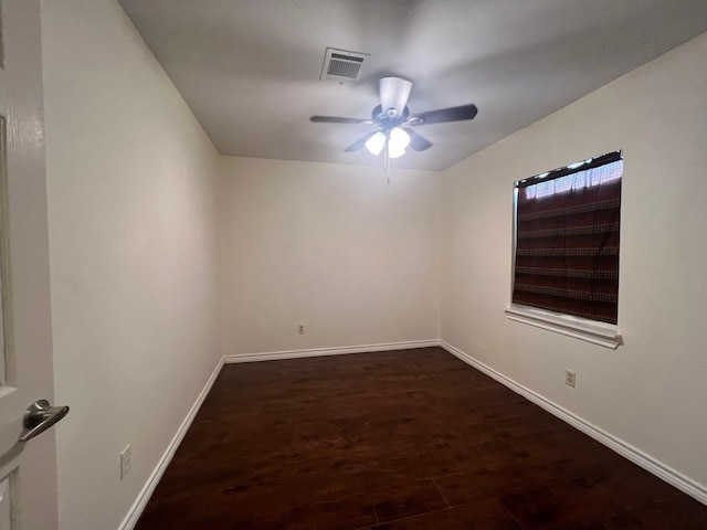 unfurnished room with baseboards, visible vents, ceiling fan, and dark wood finished floors
