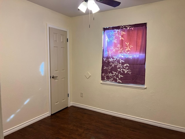 empty room featuring wood finished floors, baseboards, and ceiling fan