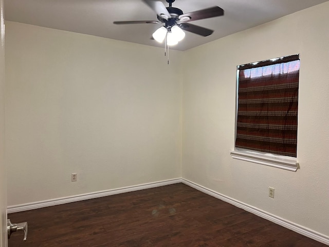 unfurnished room with dark wood finished floors, a ceiling fan, and baseboards