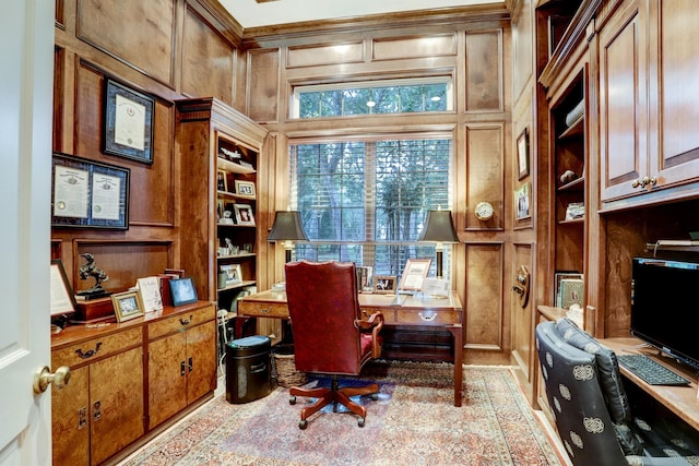 office space featuring built in shelves and wooden walls