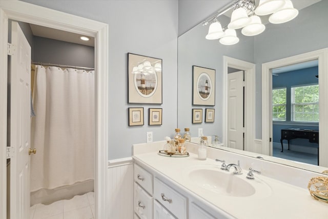 bathroom with tile patterned flooring, vanity, and walk in shower