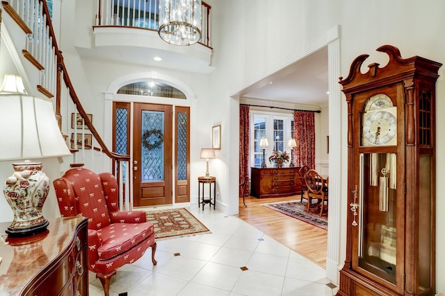 tiled entryway with a chandelier and a high ceiling