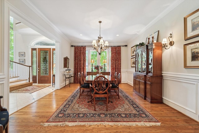 dining area featuring light hardwood / wood-style floors, a chandelier, and ornamental molding