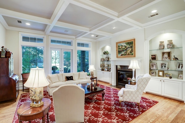 living room with built in features, beamed ceiling, coffered ceiling, and light wood-type flooring