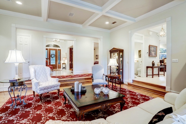 living room with beam ceiling, wood-type flooring, coffered ceiling, and ornamental molding