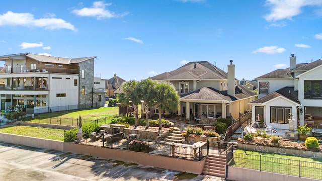 back of property with a balcony, a yard, and a patio area