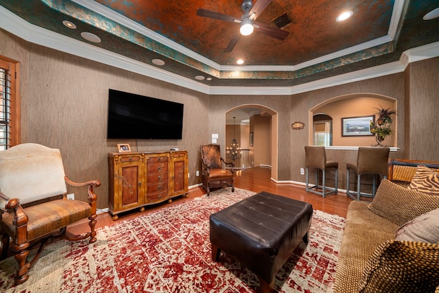 living room featuring a tray ceiling, hardwood / wood-style floors, and crown molding