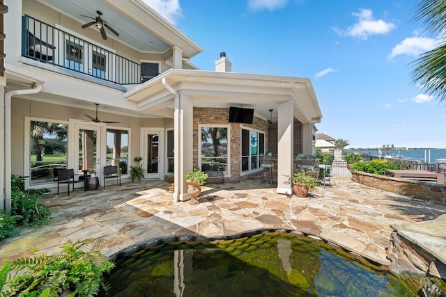 rear view of house with a balcony, a patio, and ceiling fan