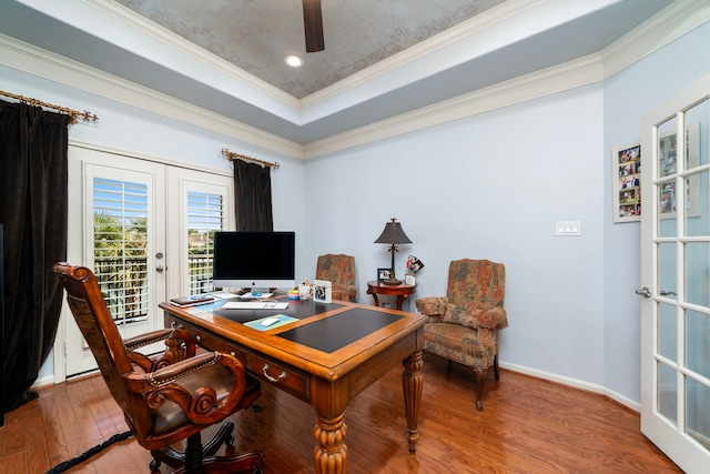 office space with wood-type flooring, a raised ceiling, crown molding, and french doors